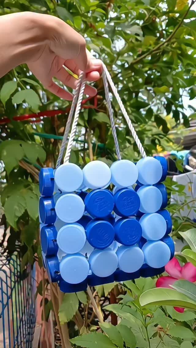 24 Art from Bottle Caps Ideas for Home, Gifts and Play 8 Small square handbag made from blue plastic bottle caps with white rope handles.
