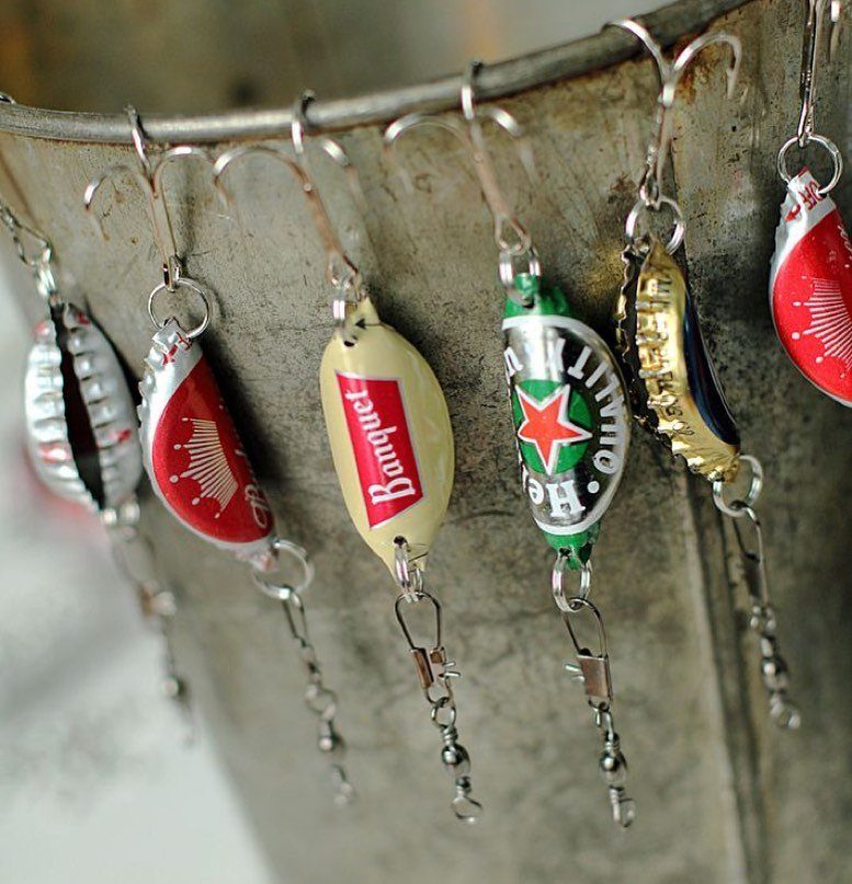 24 Art from Bottle Caps Ideas for Home, Gifts and Play 11 Bottle cap fishing lures with hooks hanging from a metal bucket rim.