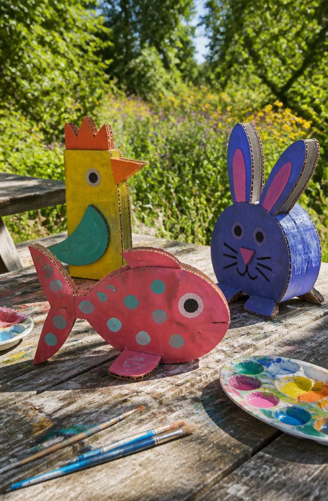 Colorful cardboard animals made from cereal boxes arranged on a table.