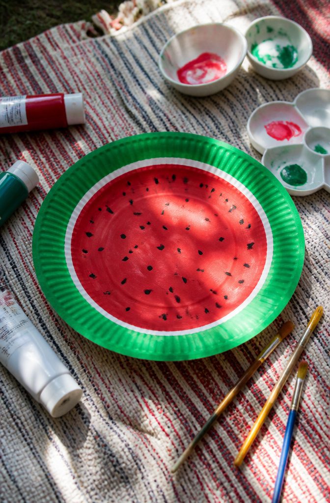 12 Easy August Crafts for Kids: Simple Summer Ideas 2 A paper plate decorated to resemble a watermelon slice.