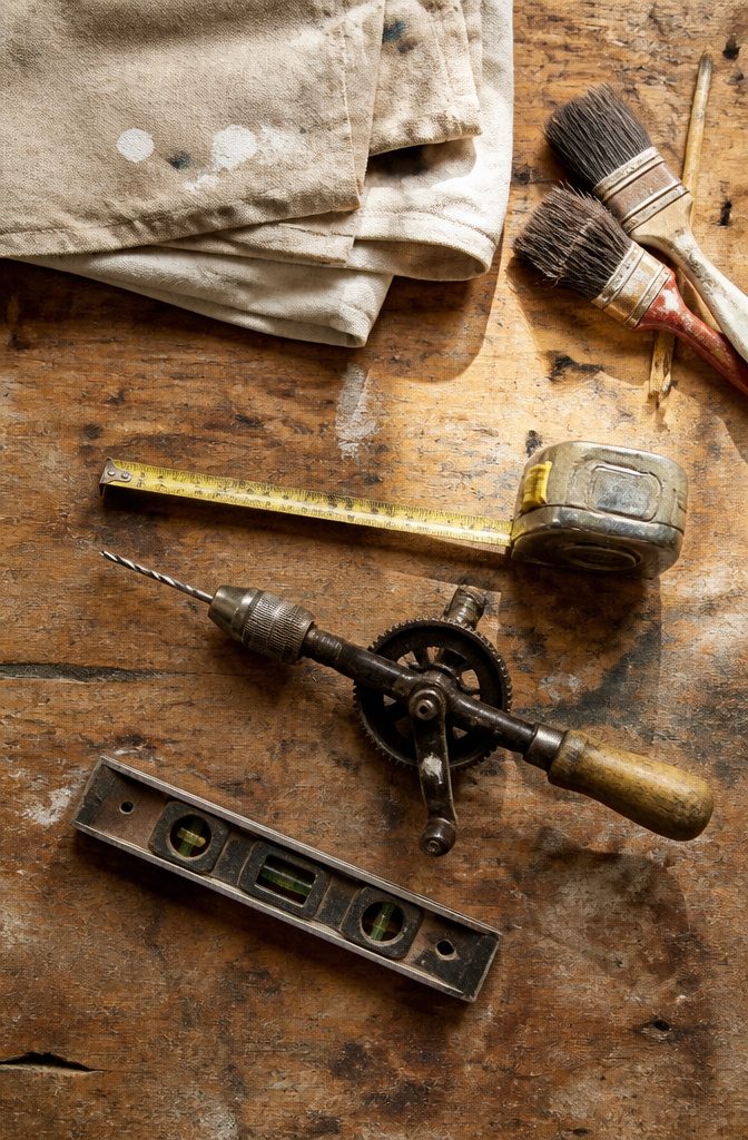 14 Budget Home Decor Ideas That Cost Almost Nothing 16 A drill and level placed on a work surface, ready for use.
