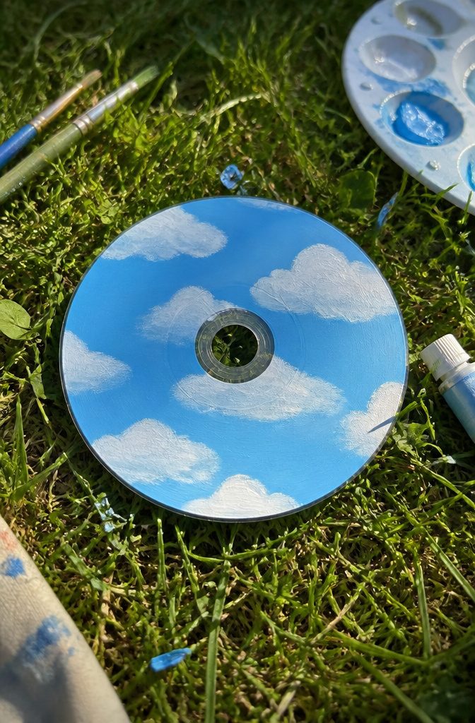 25 CD Painting Ideas for an Aesthetic Look, Easy to Copy 14 A CD features soft clouds in a blue sky design.
