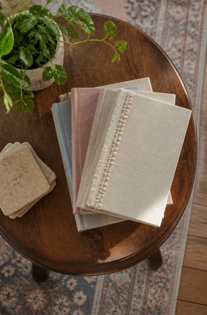Old hardcovers wrapped in fabric for a uniform display.