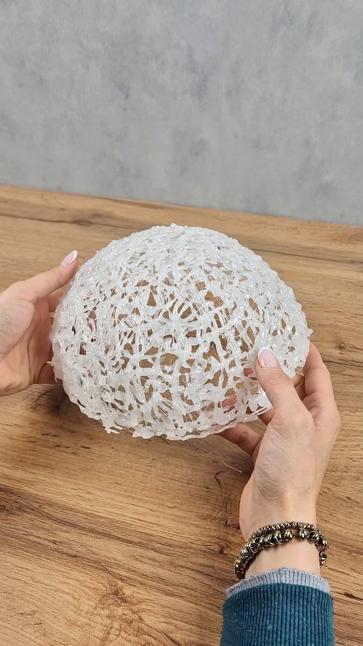 23 DIY Decor with Paper Projects for Every Room 23 White spherical paper lace decoration held by two hands over a wooden table