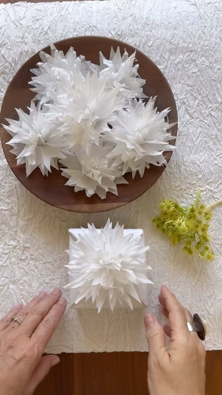 23 DIY Decor with Paper Projects for Every Room 8 White spiky paper stars in a wooden bowl and on a white table.