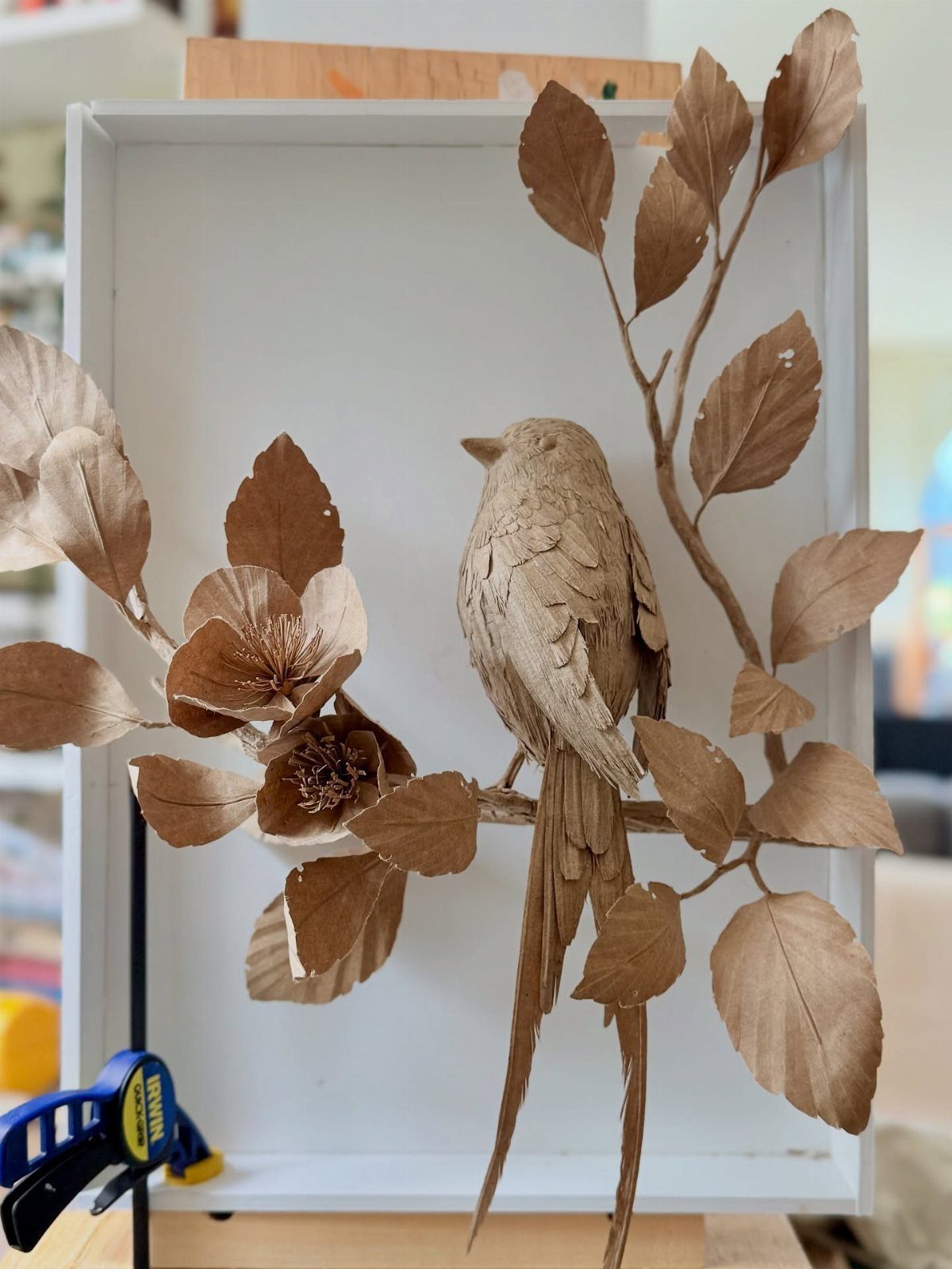 23 DIY Decor with Paper Projects for Every Room 15 Brown paper bird sculpture perched on a paper branch inside a white frame