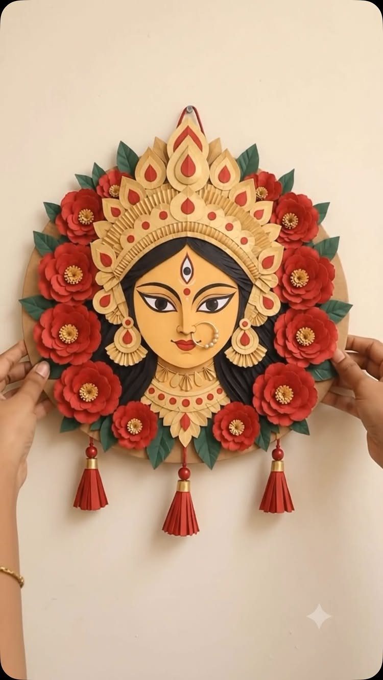 23 DIY Decor with Paper Projects for Every Room 12 Circular paper craft of a deity's face surrounded by red paper flowers and tassels.