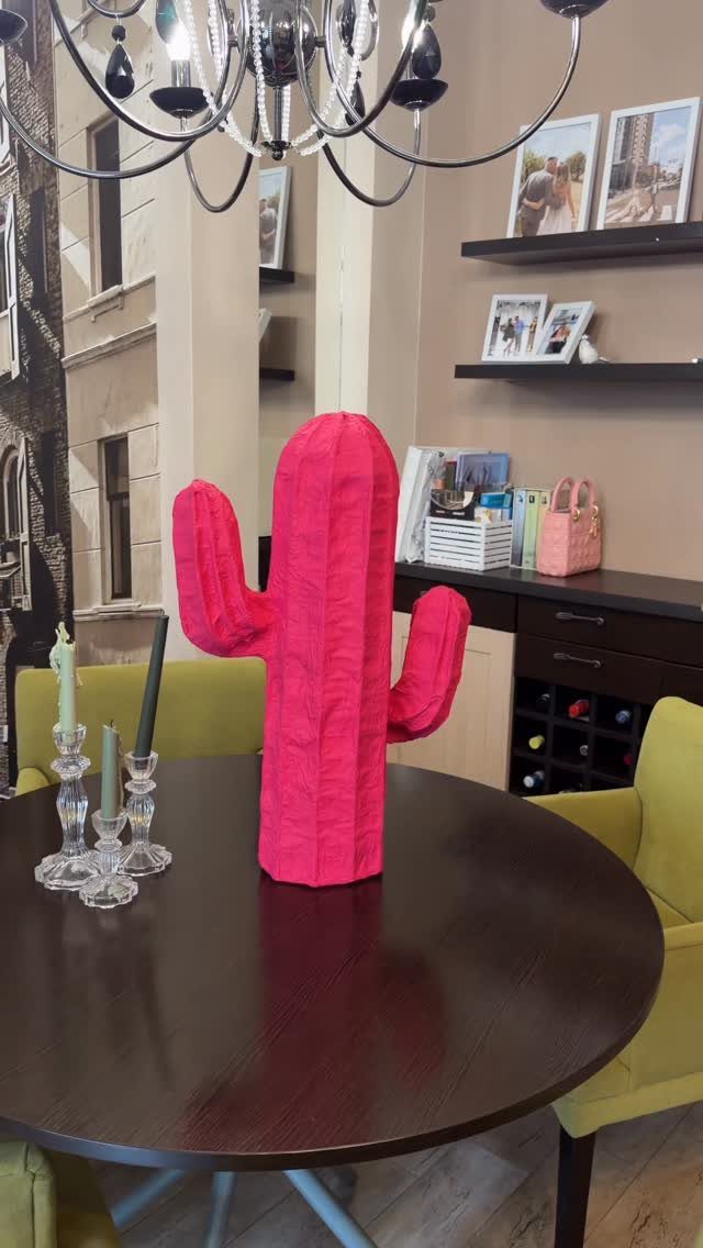 23 DIY Decor with Paper Projects for Every Room 22 Pink cactus sculpture standing on a dark wooden table in a dining room.