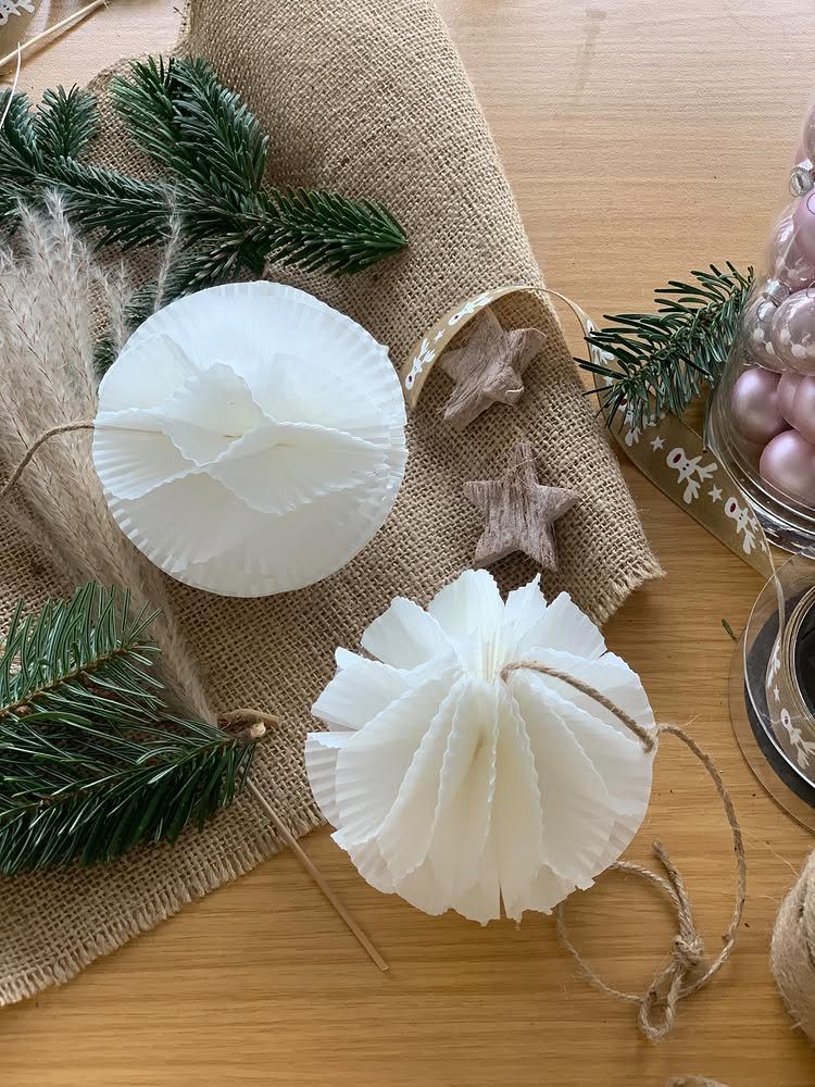 23 DIY Decor with Paper Projects for Every Room 19 White pleated paper ornaments on burlap with pine needles and small stars.