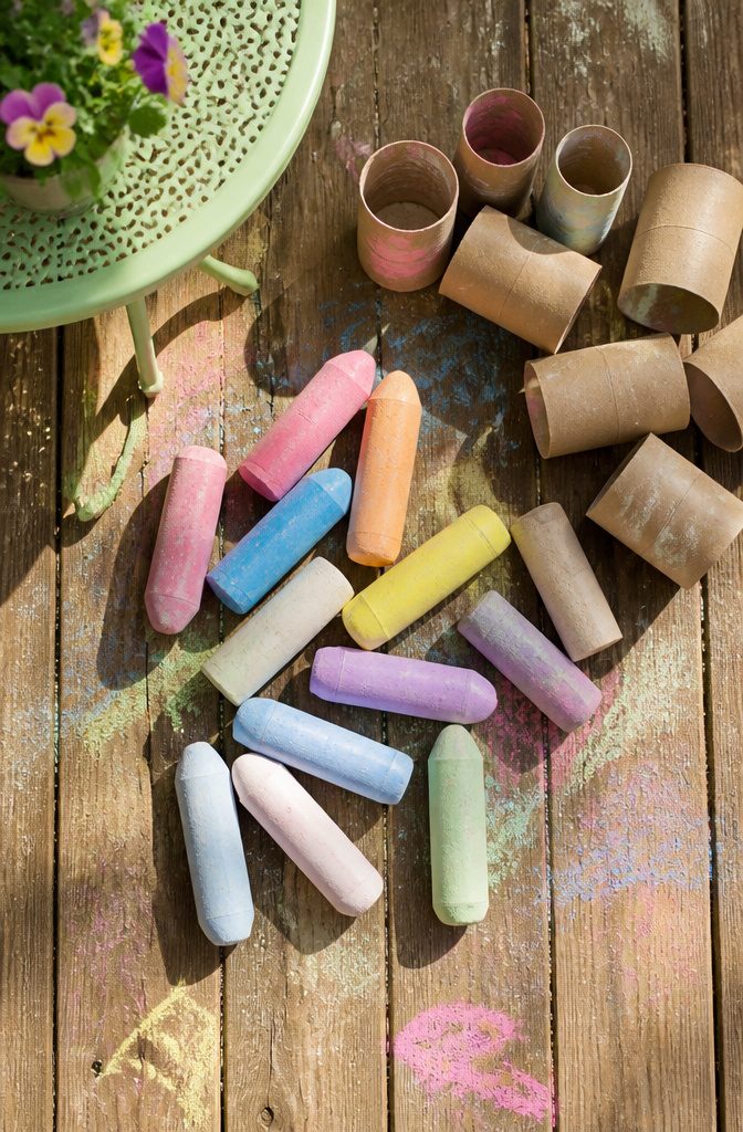 Easy Spring Crafts for Kids and Adults to Make at Home 7 Fat homemade chalk sticks resting in toilet paper roll molds.