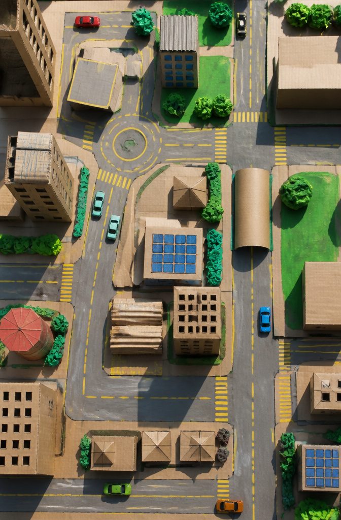 25 Ideas to Make Stuff Out of Cardboard at Home 19 Flat cardboard city with roads, buildings, and toy cars.