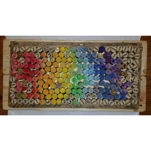 17 Recycled Art Projects for Kids and Adults to Make 13 Rainbow colored wine corks arranged in a wooden frame as decorative wall art.
