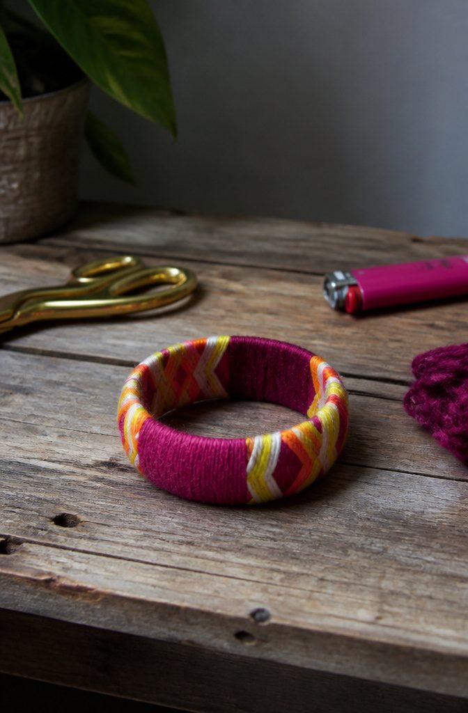 A bangle wrapped in colorful yarn.