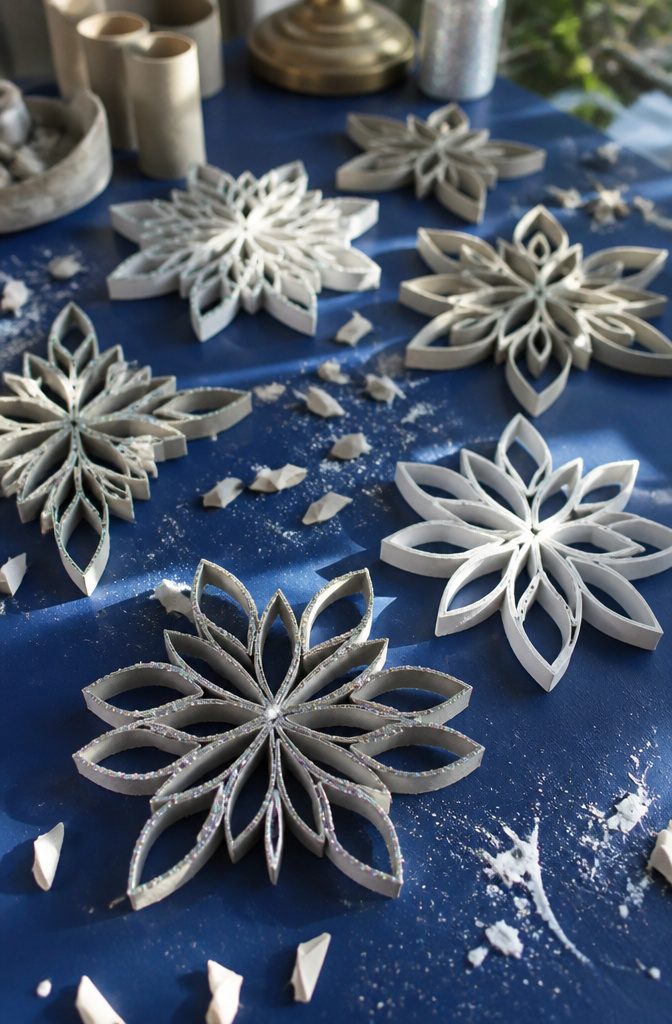25 Toilet Paper Roll Crafts Kids and Adults Can Make 11 Intricate snowflakes crafted from cut toilet paper rolls displayed.